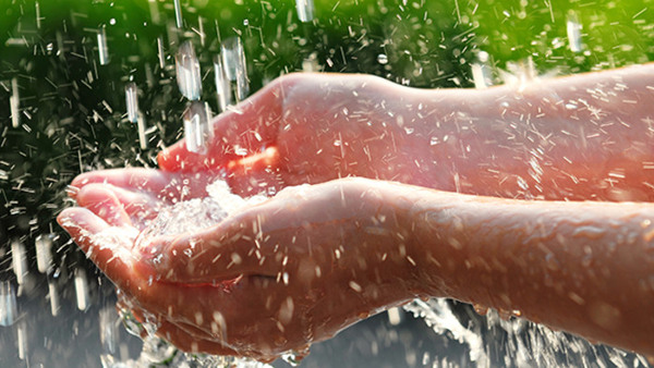 Hands catching clean falling water close up. Environmental concept.
