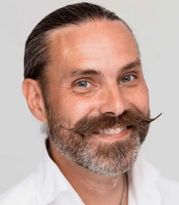 En man med mustasch i ansiktet.