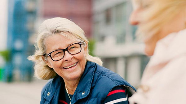 En kvinna med glasögon pratar med en annan kvinna.
