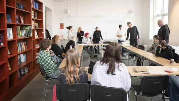 Klass på Skrivarlinjen diskuterar texter runt ett bord.