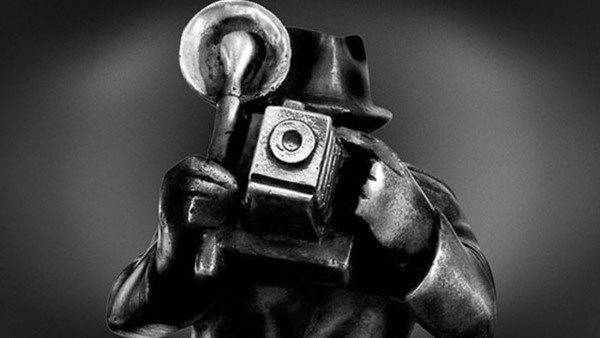 skulptur i metall person med en kamera framför ansiktet