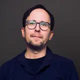 Gunnar bär glasögon och blå skjorta.