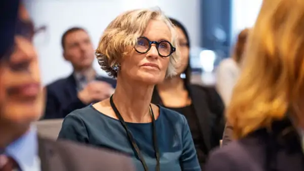 Kvinna lyssnar på Folkuniversitetets föreläsning.