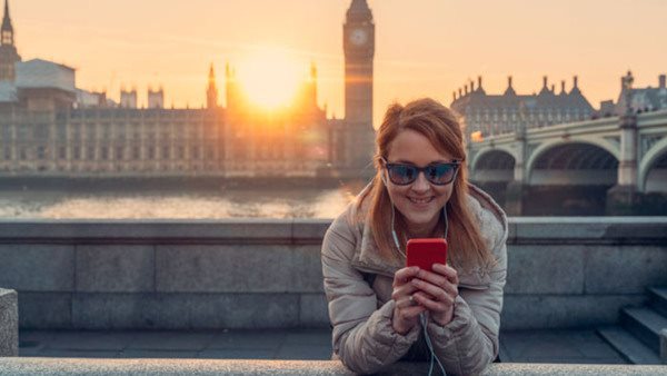 Ung person framför Big Ben i solnedgång - läser språk i London