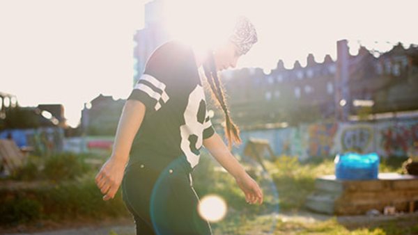 Young women dancing in the sunlight, backlit.