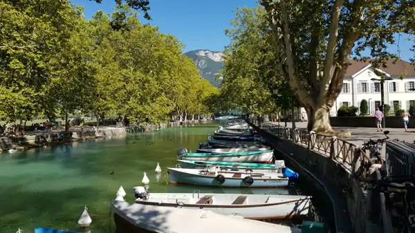 En massa båtar som ligger i vattnet i Annecy. Bo och läs franska i Annecy.