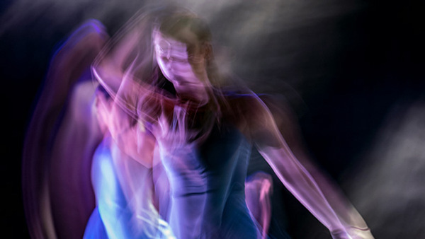 Dansare i rörelse i blått ljus.