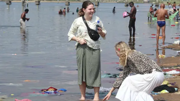 Vid den heliga floden, två elever känner på vattnet