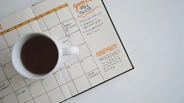 En kopp kaffe ovanpå en kalender