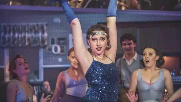 Elev på scen i Great Gatsby outfit. 
