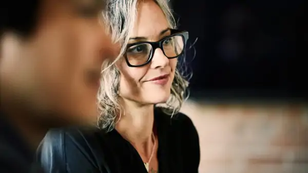 Woman turned away from camera, listening intently with interest during a lesson. 