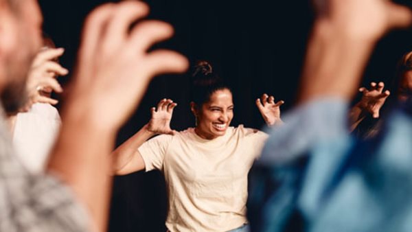 Cirkel med deltagare på kurs i scenkonst jobbar med hand- och ansiktsuttryck