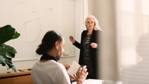 Klassrum med lärare och deltagare på ekonomikurs