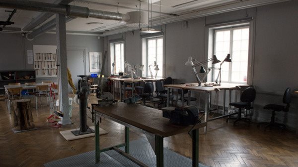 Ljust hantverksrum med arbetsbänkar, lampor och verktyg - kurslokal för luffarslöjd och metallhantverk