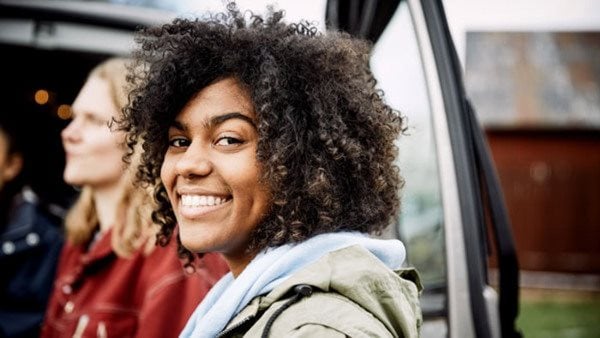 Grupp leende personer framför en minibuss - deltar i kurs i swahili