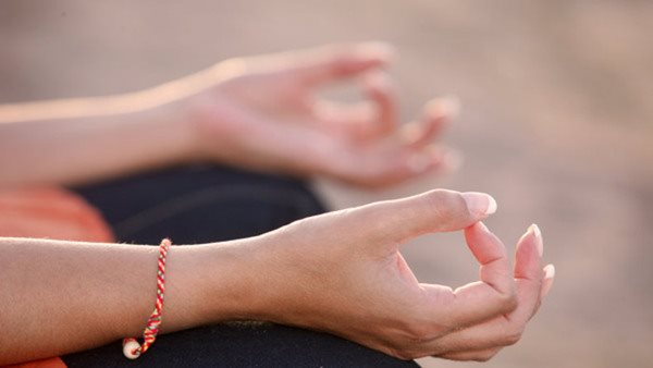 Person i meditationsställning under friskvårdskurs - fokus på avslappning och närvaro